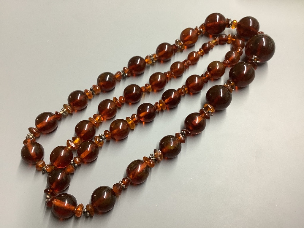 Two single strand reconstituted and natural amber necklaces, both approximately 80 cm, gross weight 172 grams.